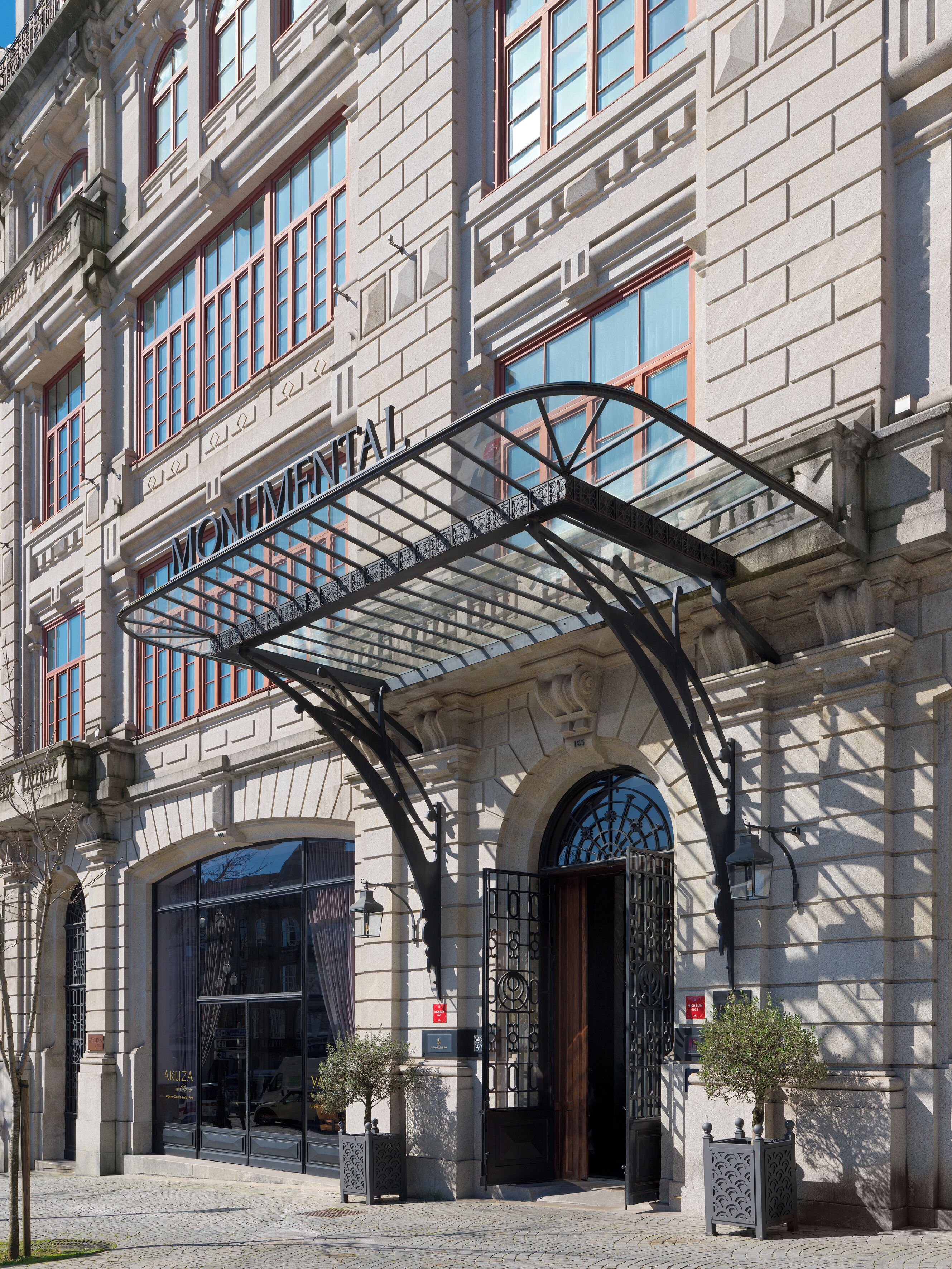 Un edificio histórico con una entrada destacada, un toldo metálico y un amplio ventanal.