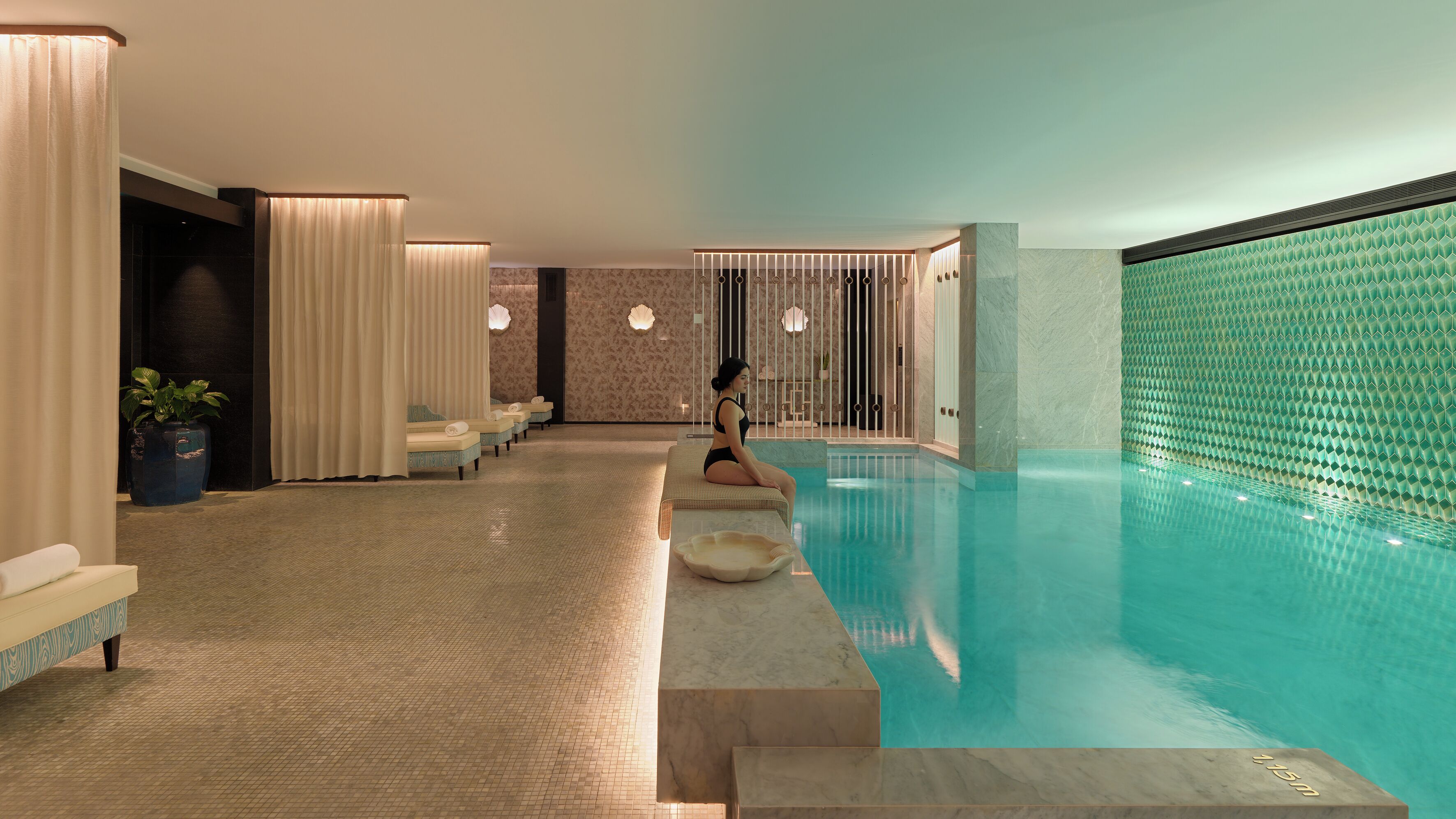 Uma área de spa com piscina, área de estar e sala de massagem.