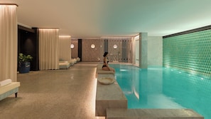 A spa area with a pool, seating, and a massage room. - The One Monumental Palace (Porto)