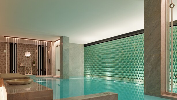 A modern indoor pool with a geometric tile wall, a marble bench, and a minimalist design. - The One Monumental Palace (Porto)