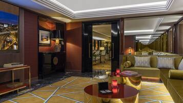 Un lobby de hotel lujoso con piso de mármol, una mesa redonda para café, un sofá y vista a la Torre Eiffel a través de un ventanal grande.