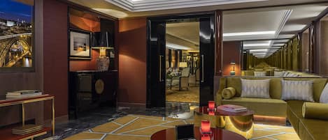A luxurious hotel lobby with a marble floor, a round coffee table, a sofa, and a view of the Eiffel Tower through a large window.