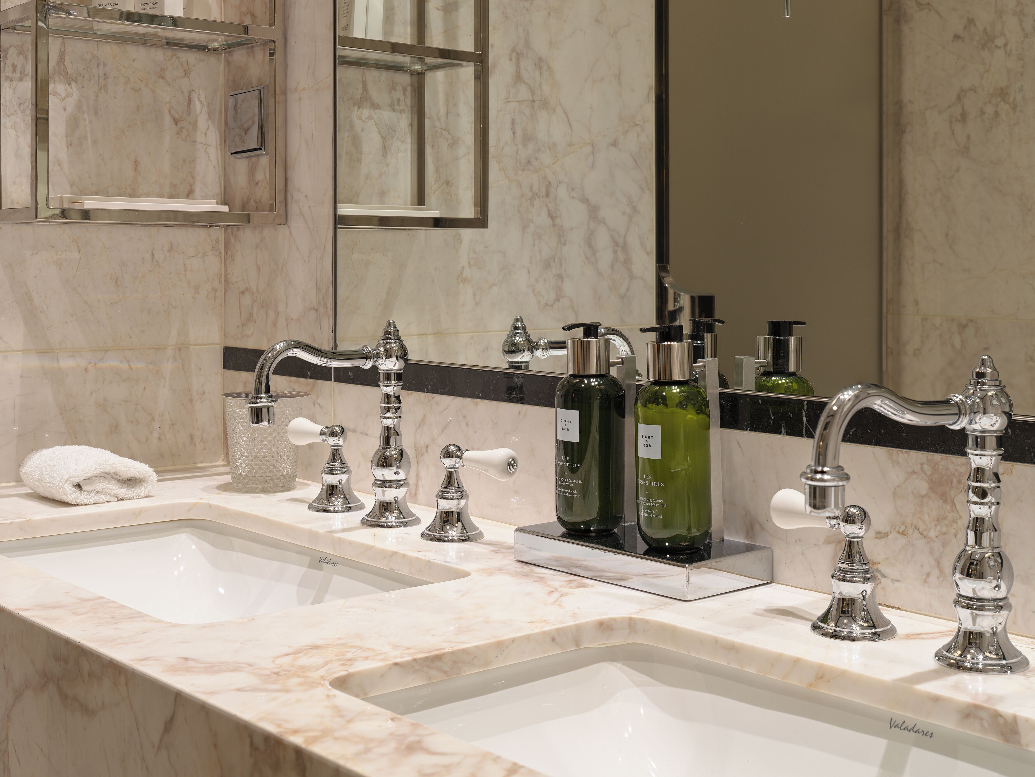 A bathroom with two sinks, a mirror, and a towel.