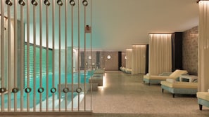 Un área de spa con piscina, asientos y un mostrador de recepción.