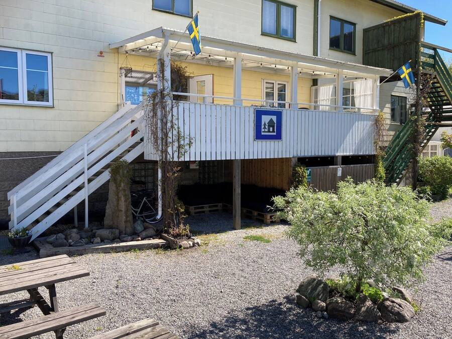 Un edificio con un espacio al aire libre cubierto, una escalera y una bandera.