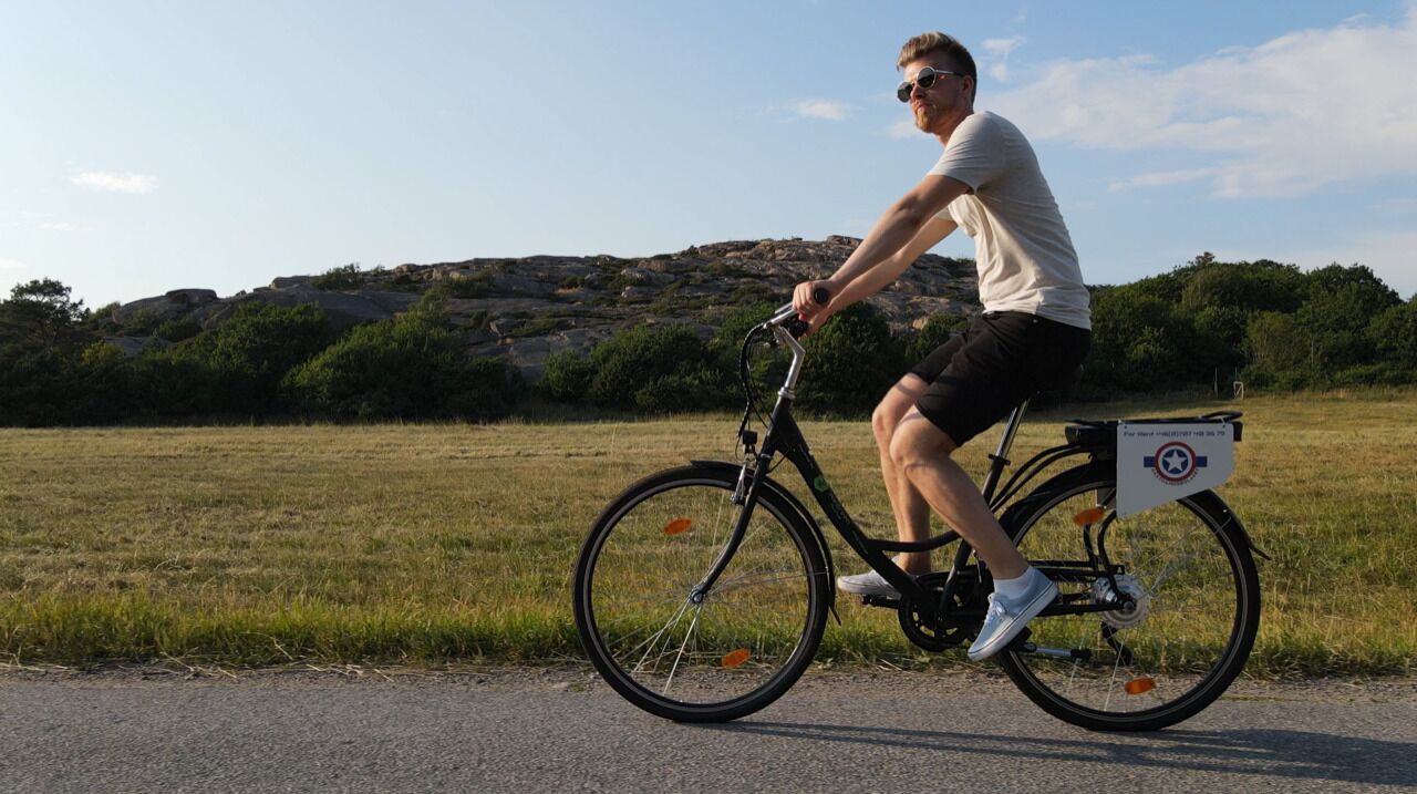 Eine Person fährt Fahrrad, mit einer Gepäckbox am Hinterrad.