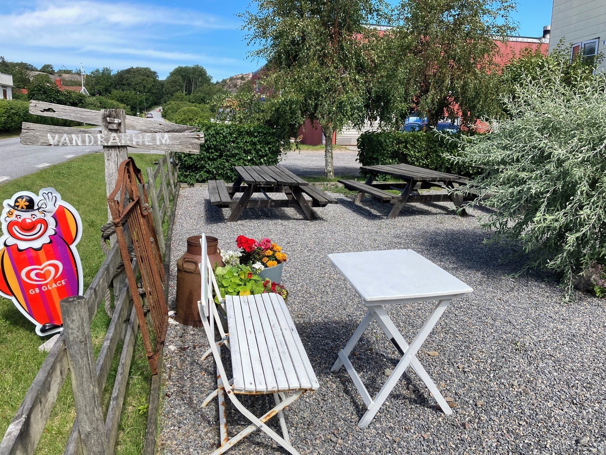 Un espace pique-nique avec des bancs et une table en bois, entouré de gravier.