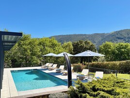 Una piscina al aire libre de temporada, sillones reclinables de piscina