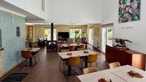 A spacious room with a fireplace, dining area, and a large painting on the wall. - Casa Carvalhal - Adults Only (Góis)
