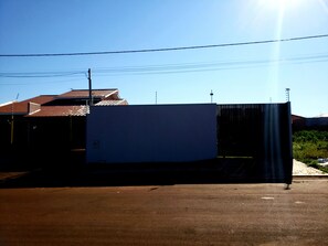 A large industrial building with a flat roof and a metal fence in front. - Casa M&N (Foz do Iguaçu)