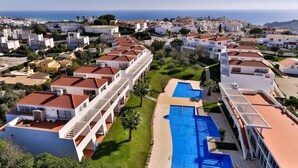 A resort with multiple buildings, a swimming pool, and a view of the sea. - Pateo Village Apartments (Albufeira)