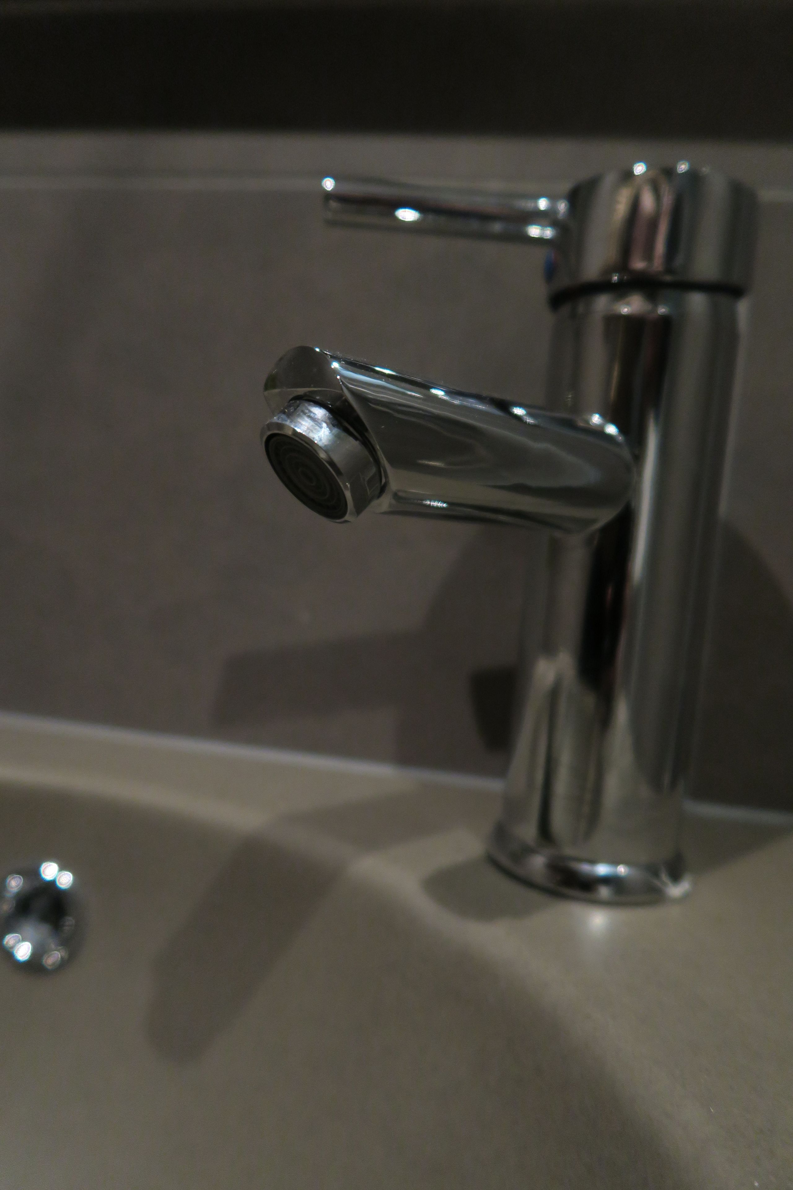 Ein chromfarbener Wasserhahn mit einem Einhandgriff auf einer Arbeitsplatte.