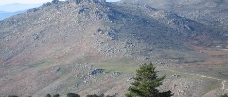 Un paisaje montañoso con terreno rocoso y vegetación escasa.
