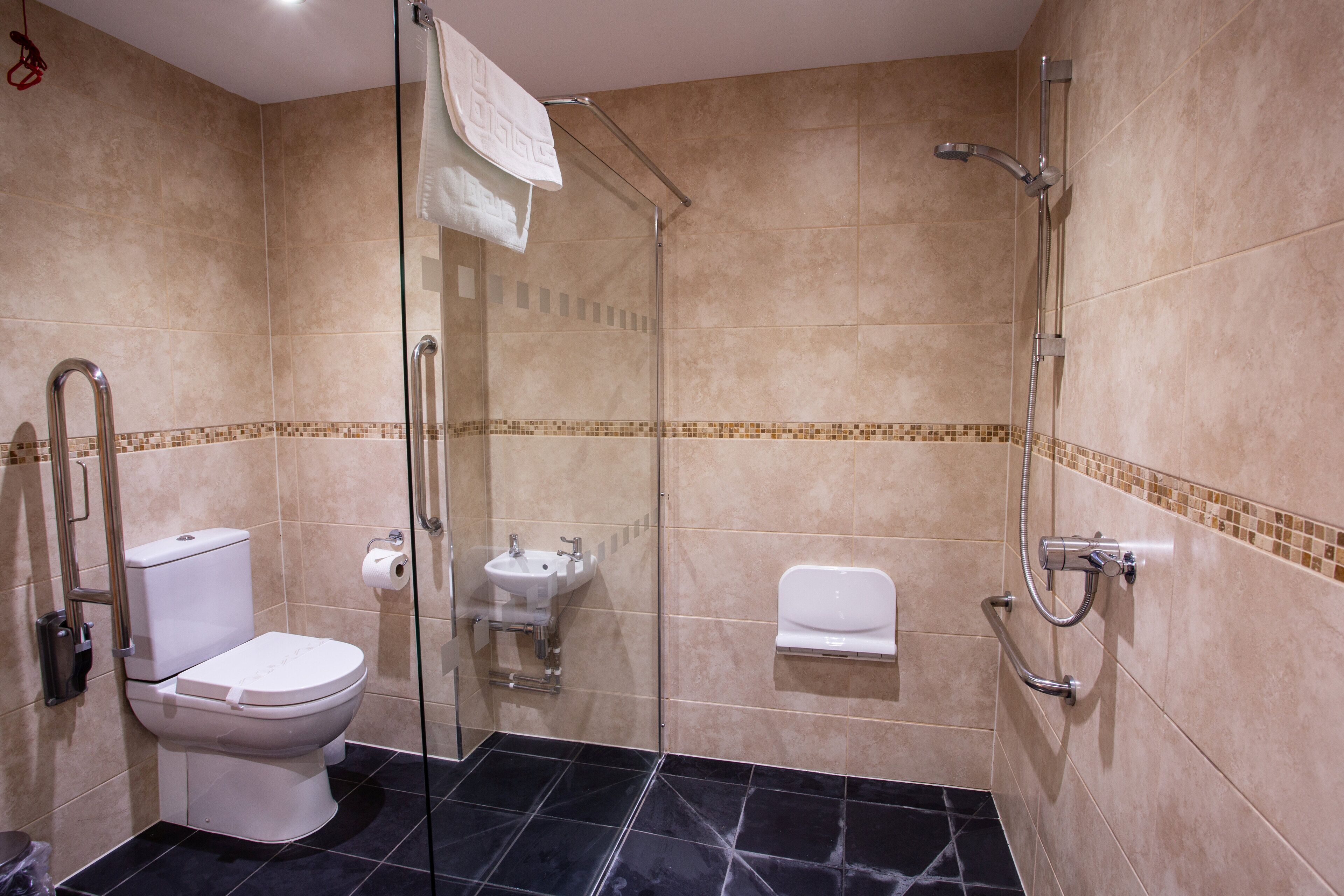 A modern bathroom with a toilet, sink, and shower.