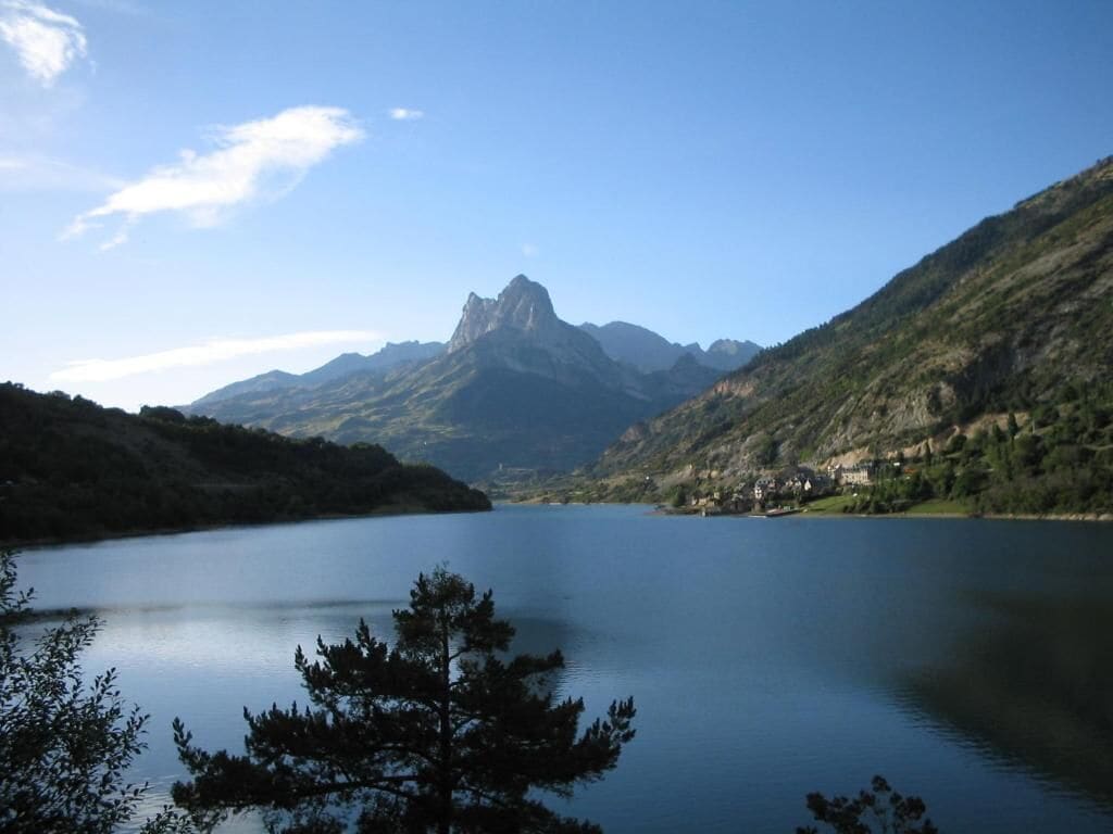 A lake surrounded by mountains with a clear sky.