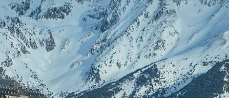 A mountain town with snow-covered peaks, traditional chalet-style buildings, and a church.