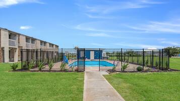 Enjoy a refreshing swim in the pool surrounded by lush greenery and a beautifully maintained outdoor space.