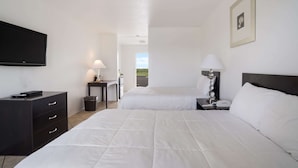 A hotel room with two beds, a TV, a desk, and a lamp. - Rodeway Inn at Somers Cove Marina (Crisfield)