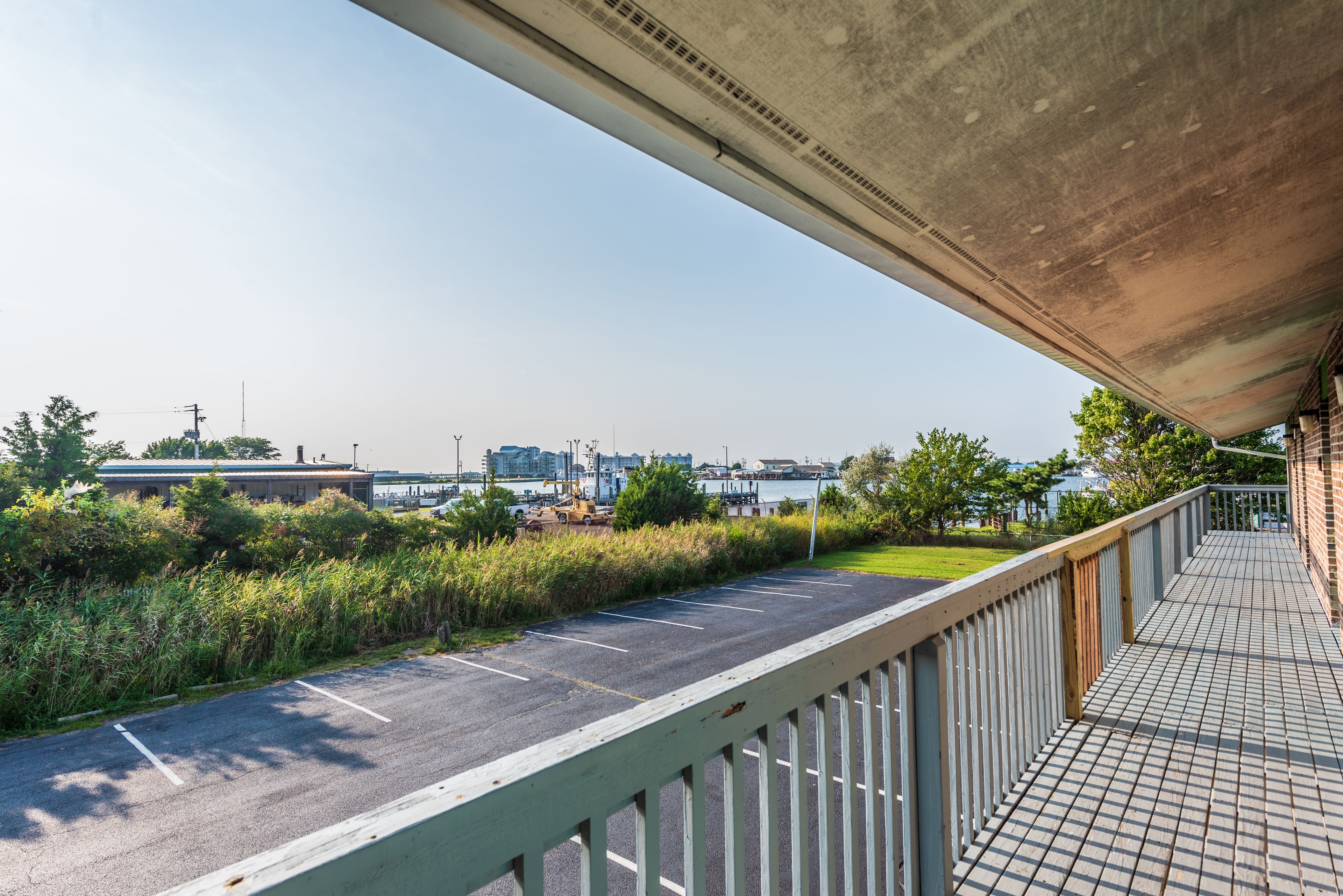 A parking area with a view of a bridge and industrial buildings in the background.