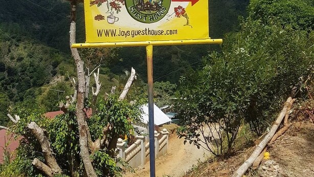 Señal para Jay's Guest House con una flecha indicativa.