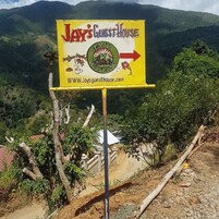 A sign for Jay's Guest House with a directional arrow.