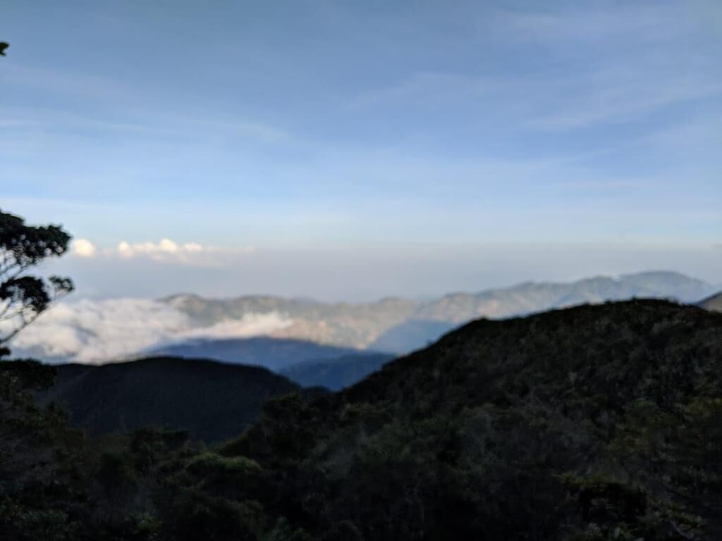 Paisagem montanhosa com vista para montanhas distantes e nuvens.