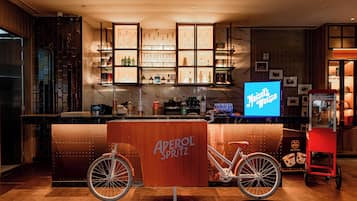 A bar area with a wooden counter, a neon sign, and a bicycle.