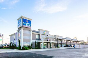 A multi-story Express Inn hotel with a prominent sign, a covered entrance, and a parking lot. - Express Inn - Spring (Spring)