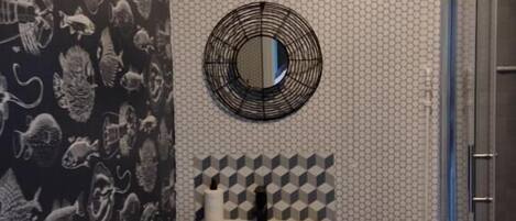 A bathroom with a sink, mirror, and shower.