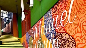 Una scala con motivi colorati e la scritta 'Manuel Antonio Hostel' sul muro.