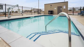 Una piscina al aire libre, sillones reclinables de piscina