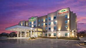 Ein Hawthorn Extended Stay Hotel mit modernem Design, einer überdachten Eingangspforte und einem Parkplatz.