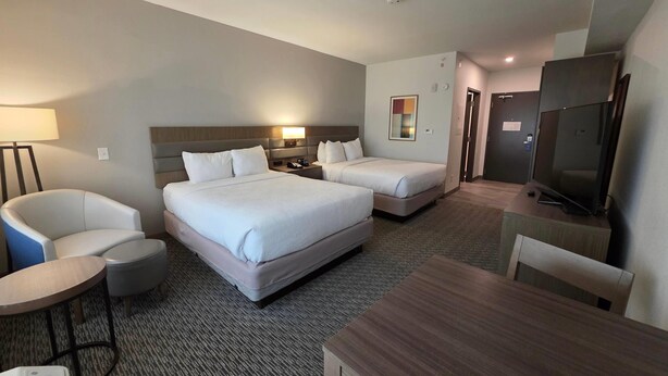 A hotel room with two beds, a desk, a chair, a TV, and a lamp. - Wingate by Wyndham Austin North (Austin)