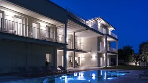 A multi-story building with a swimming pool, balconies, and outdoor seating areas. - L.A. Home (Moniga del Garda)