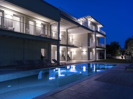 Una piscina al aire libre de temporada, sillones reclinables de piscina