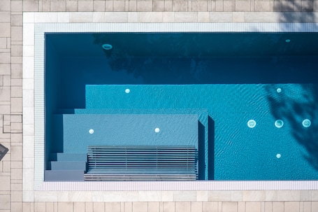 Una piscina al aire libre de temporada, sillones reclinables de piscina