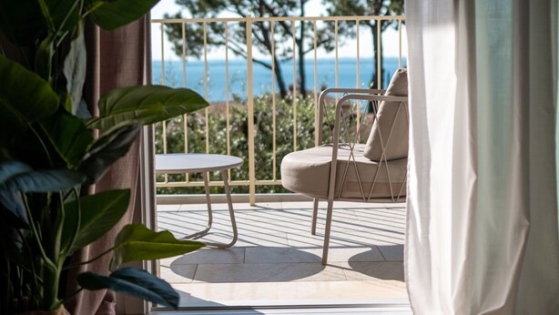 A room with a view of the sea, a chair, and a potted plant. - L.A. Home (Moniga del Garda)