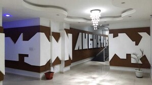 Eine moderne Lobby mit geometrischen Wandmustern und einer Treppe.