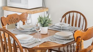 A dining table set with plates, glasses, and a small plant. - Beautiful View of Rustico Bay (North Rustico)