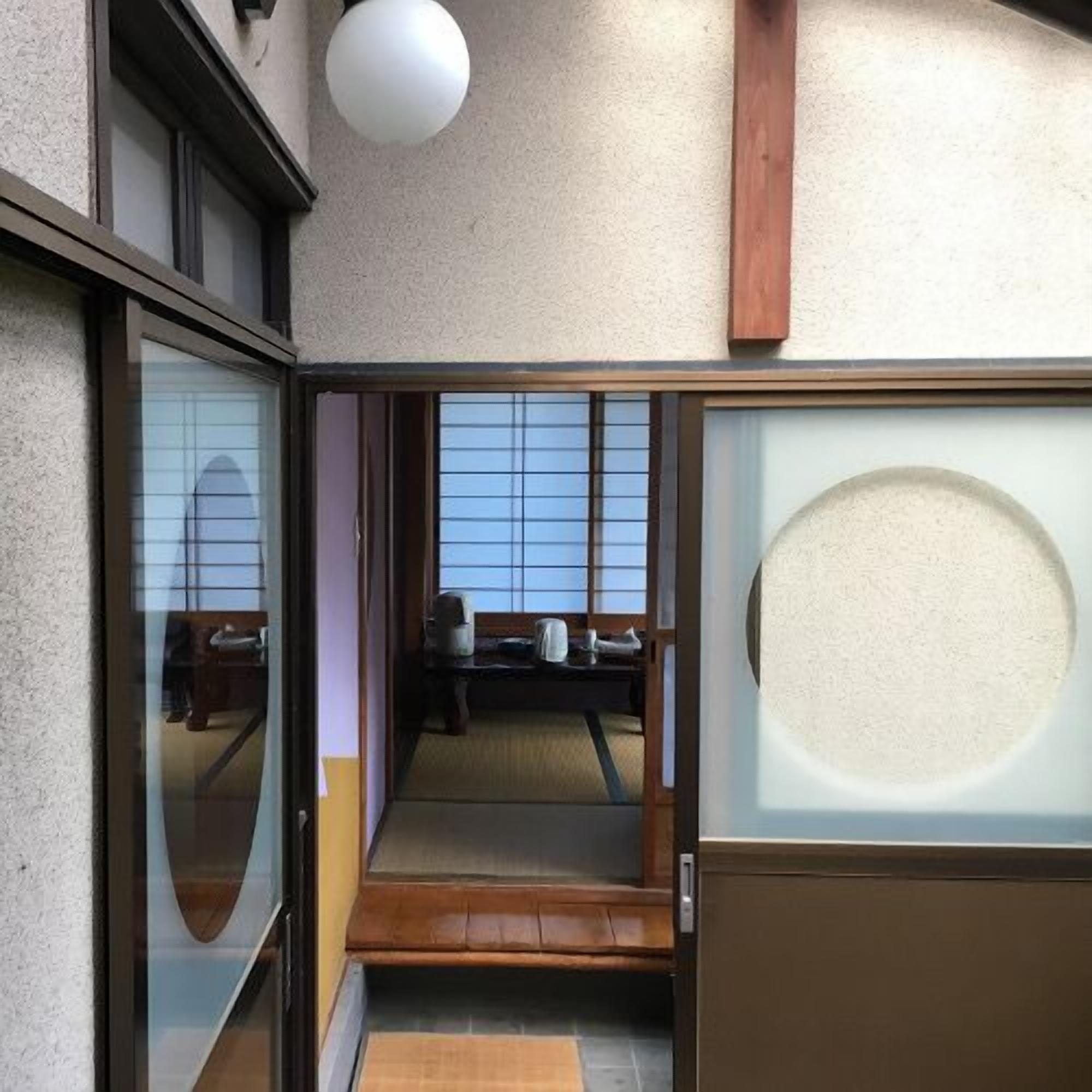 Habitació japonesa tradicional amb portes corredisses, tatami i vistes a l'exterior.