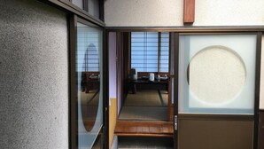 A traditional Japanese room with tatami flooring, a sliding door, and a shoji screen. - Masugataya Inn (Tako)