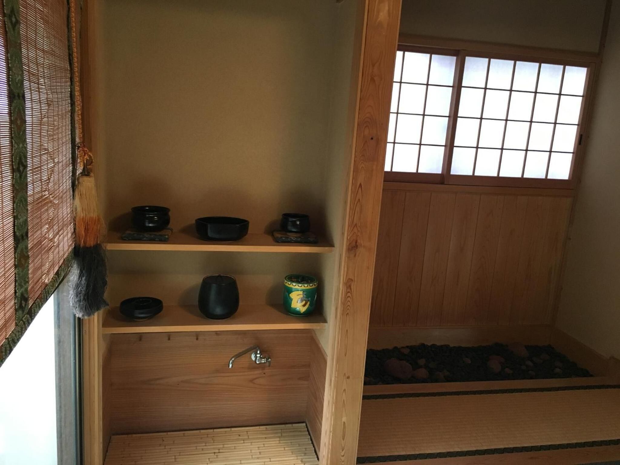 Une pièce de style japonais traditionnel, avec un sol recouvert de tatamis, une porte coulissante et une fenêtre à carreaux.
