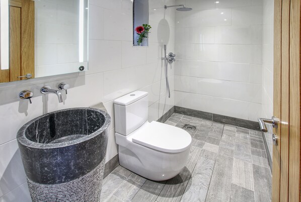 A modern bathroom with a toilet, bidet, and shower.