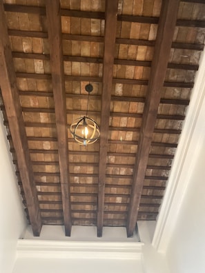 A wooden ceiling with exposed beams and a hanging light fixture. - 352 Guest House (San Juan)