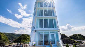 A multi-story hotel with a prominent tower-like structure, large windows, and a view of the surrounding landscape. - Brighthouse (Suao)