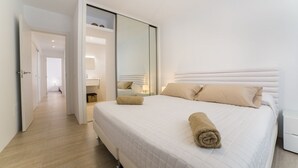 Een hotelkamer met een groot bed, een kledingkast en een spiegel.
