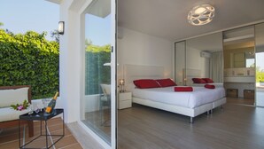 Een moderne slaapkamer met een groot bed, een glazen deur die leidt naar een balkon, en een badkamer met een grote spiegel.