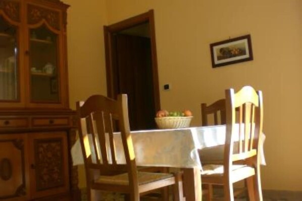 Un comedor con una mesa, sillas, un armario y una puerta.