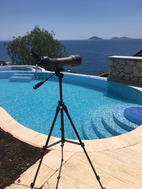 A telescope on a tripod by a swimming pool with a view of the sea and a stone wall. - Luxury villa with private infinity pool and jacuzzi within 80metres of the sea (Antalya)