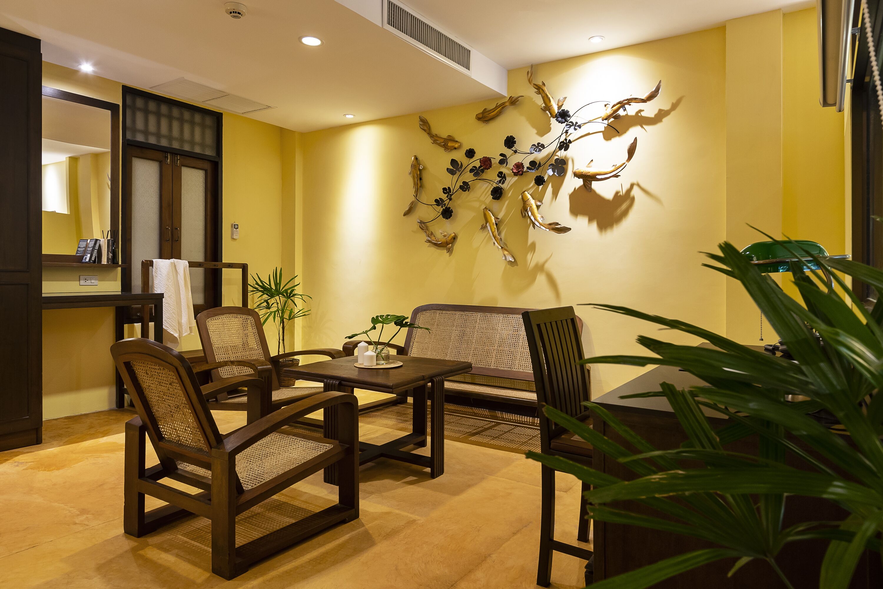 Un salón moderno con un sofá, sillones, una mesa de centro y un adorno en la pared.